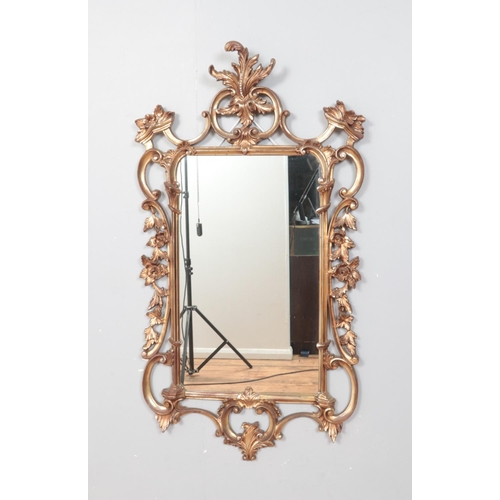 299 - An ornate gilt framed wall mirror. Height: 105cm, Width: 57cm.