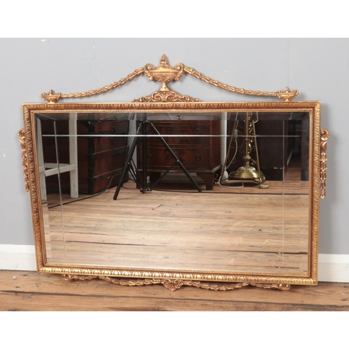 307 - An ornate gilt framed bevel edge mirror. Approx. dimensions 87cm x 52cm.