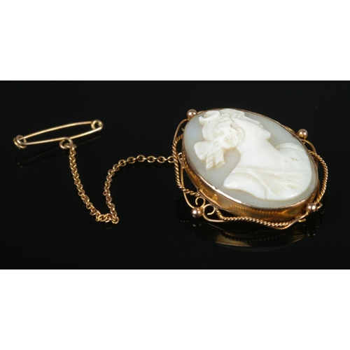 326 - A 9ct Gold cameo brooch depicting a maiden, on safety chain. Length: 3.5cm. Total weight: 6.6g.