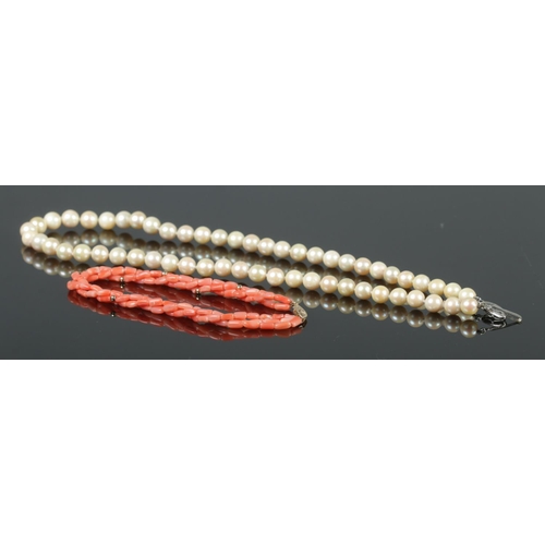 336 - A cultured pearl necklace on silver clasp, together with a twisted three strand coral bracelet on 14... 