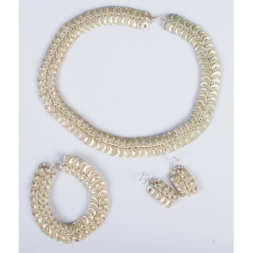 348 - An Indian silver three piece jewellery suite. Comprising of necklace, bracelet and earrings. 174g.