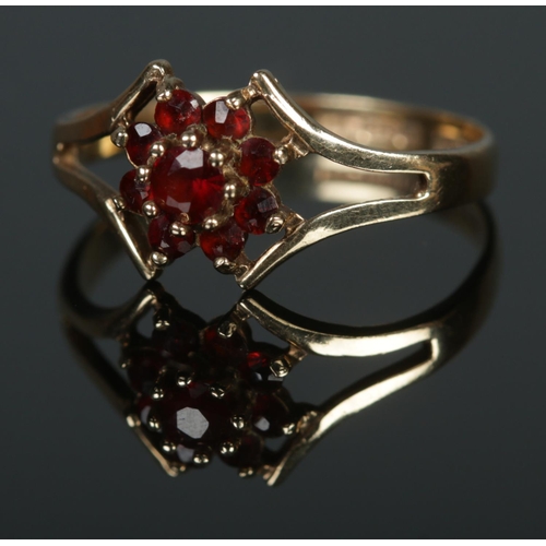 381 - A 9ct gold cluster ring set with nine garnets. Size M, 1.48g.