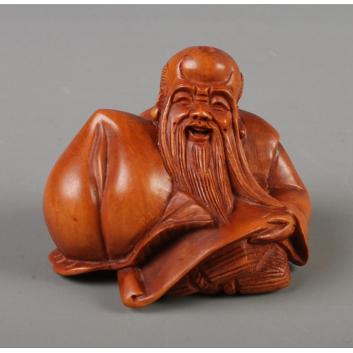 384 - A Japanese carved Netsuke in the form of the god of longevity, signed to base.