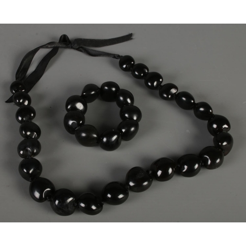 98 - A large black bead necklace with matching bracelet.