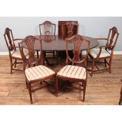 419 - A mahogany twin pedestal extending dining table, with additional leaf and six wheat back dining chai... 