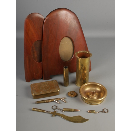 148 - A collection of trench art and military themes brassware including artillery shell, letter opened, b... 