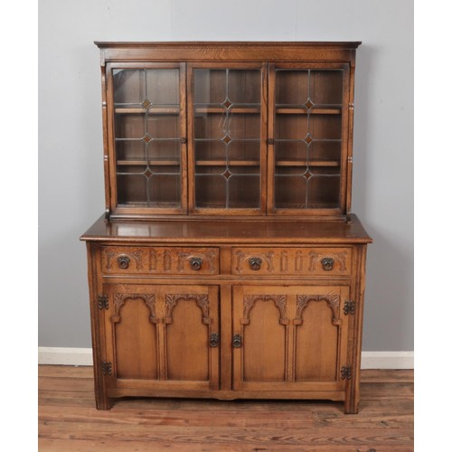 463 - A carved oak dresser with glazed top half. Height 168cm, Width 126cm, Depth 48cm.