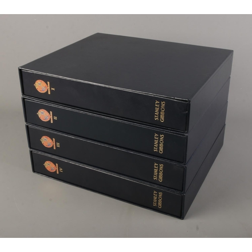 10 - Four-volume set of the Stanley Gibbons albums in slip cases for Great Britain, first album partially... 