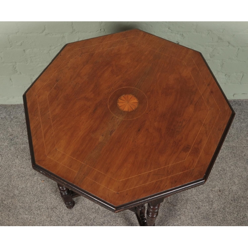 410 - A walnut and rosewood octagonal window table with fan patera.