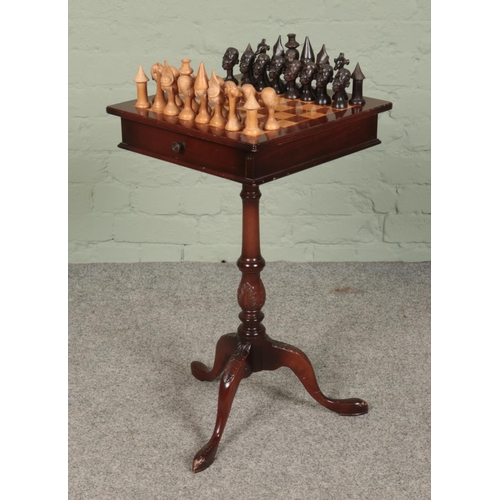 419 - A mahogany chess table, on turned central pillar supported by carved tripod base. With double sided ... 