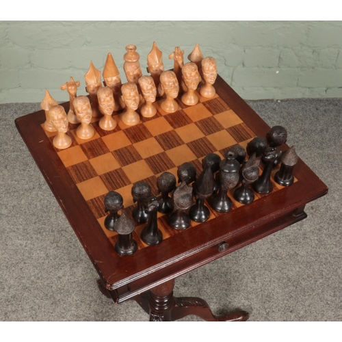 419 - A mahogany chess table, on turned central pillar supported by carved tripod base. With double sided ... 