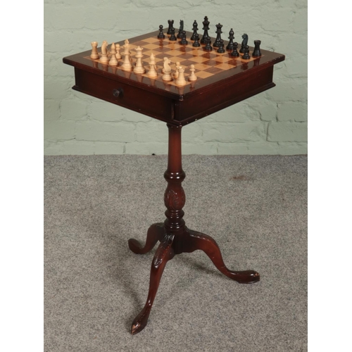 419 - A mahogany chess table, on turned central pillar supported by carved tripod base. With double sided ... 