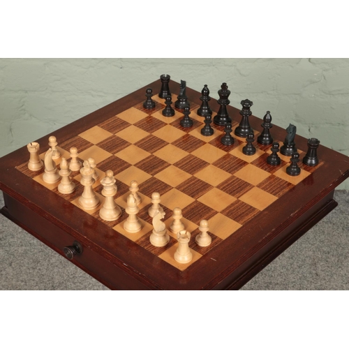 419 - A mahogany chess table, on turned central pillar supported by carved tripod base. With double sided ... 