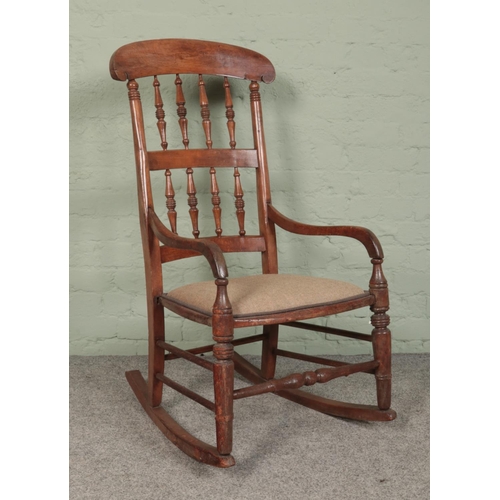 422 - An oak rocking chair, with central turned stretcher and spindle back.