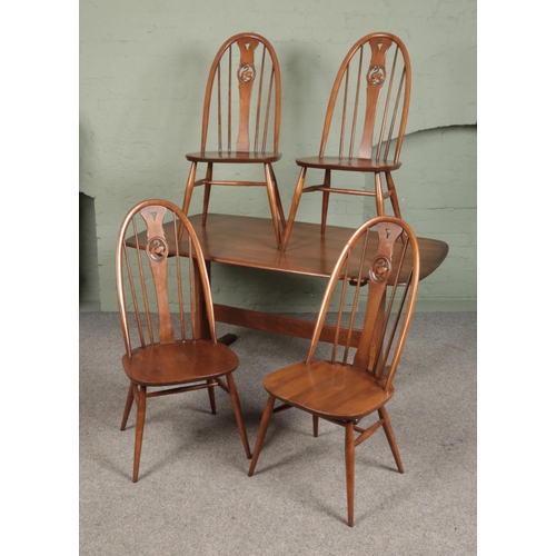 An Ercol dining table with four quaker swan back chairs.