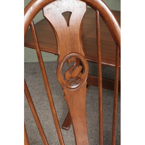 424 - An Ercol dining table with four quaker swan back chairs.