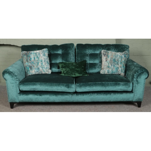 385 - A teal velvet upholstered three seat sofa. (80cm x 225cm x 95cm)