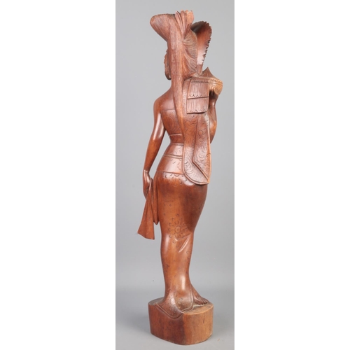 120 - A large vintage Oriental carved wooden figure of a young maiden (59cm).