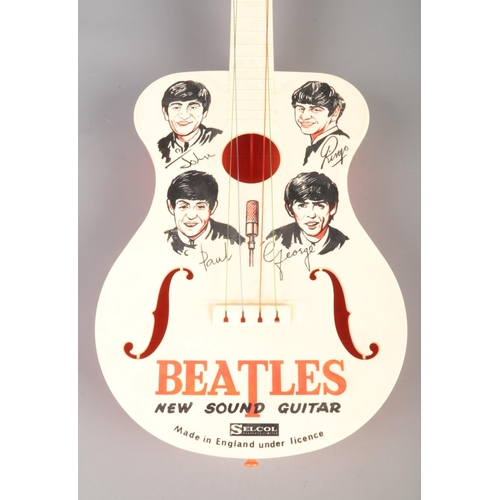 73 - The Beatles; A Selcol plastic toy guitar, Made in England under license.