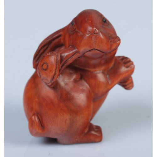 335 - A Japanese carved Netsuke in the form of a rabbit with ruyi.