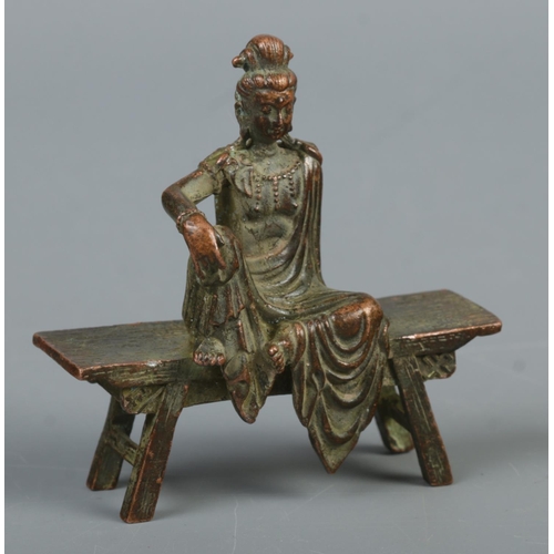 341 - A cast metal sculpture of Guanyin the god of mercy seated on a bench

Approximate height 8cm