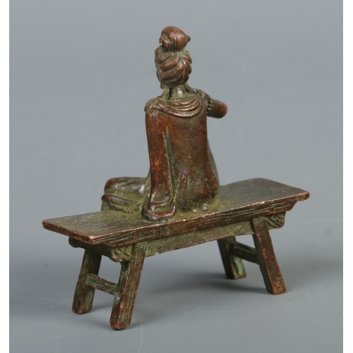 341 - A cast metal sculpture of Guanyin the god of mercy seated on a bench

Approximate height 8cm