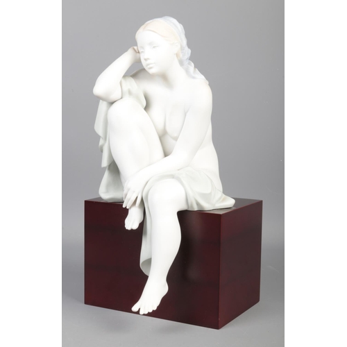 344 - A Limited Edition Lladro figure; 'Lost in Thought', raised on wooden base. No. 215/1500. With detail... 