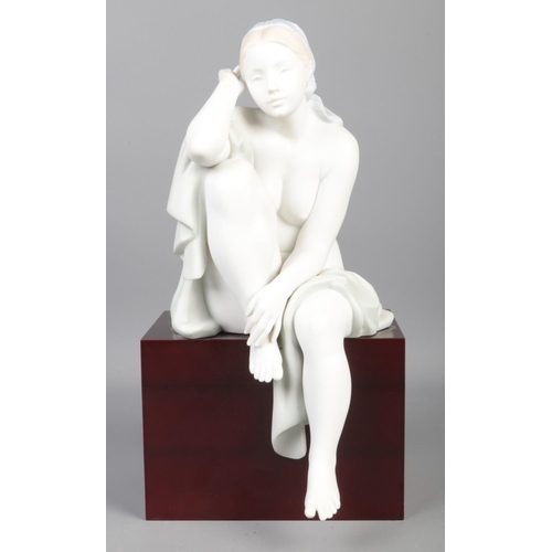 344 - A Limited Edition Lladro figure; 'Lost in Thought', raised on wooden base. No. 215/1500. With detail... 