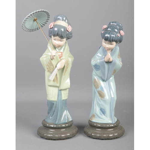 348 - Two Lladro Geisha Girls; with one holding a parasol. Tallest: 29cm.