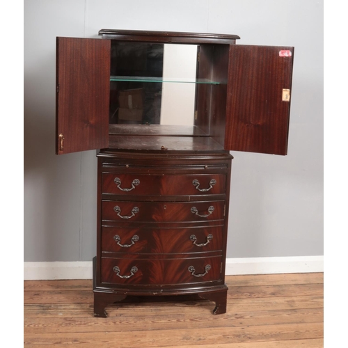 365 - A bow fronted mahogany drinks cabinet, with cupboard doors, pull-out shelf and fake drawers to the b... 