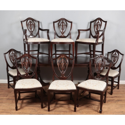 377 - A mahogany twin pedestal extending dining table with lion paw feet including additional leaf and eig... 