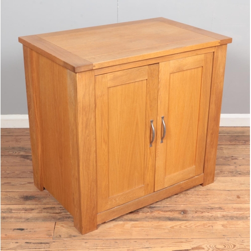 378 - A modern oak cabinet with double doors and sliding interior shelf. Hx85cm Wx90cm Dx58