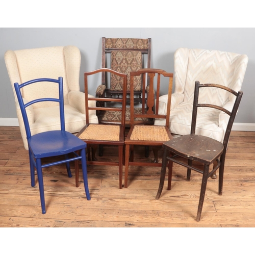 382 - A quantity of chairs. Includes two upholstered wingback armchairs, American rocking chair, etc.