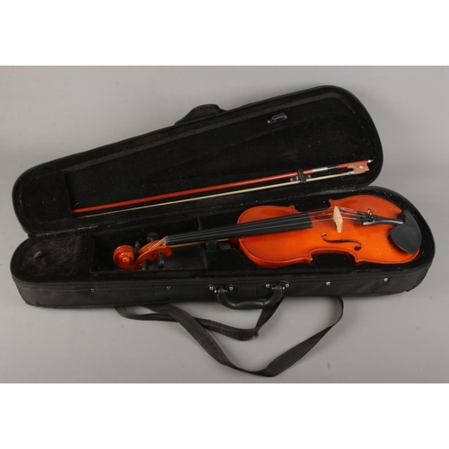 61 - A cased violin with bow. The violin having a one piece 14 inch back.