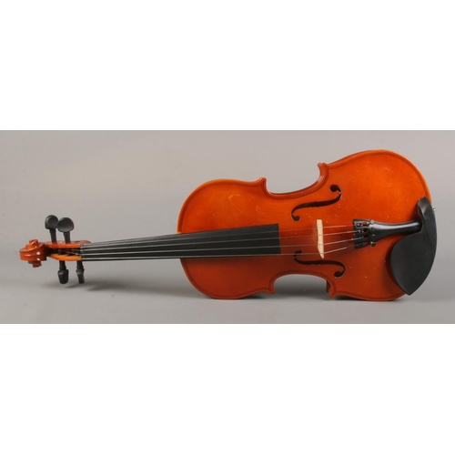 61 - A cased violin with bow. The violin having a one piece 14 inch back.