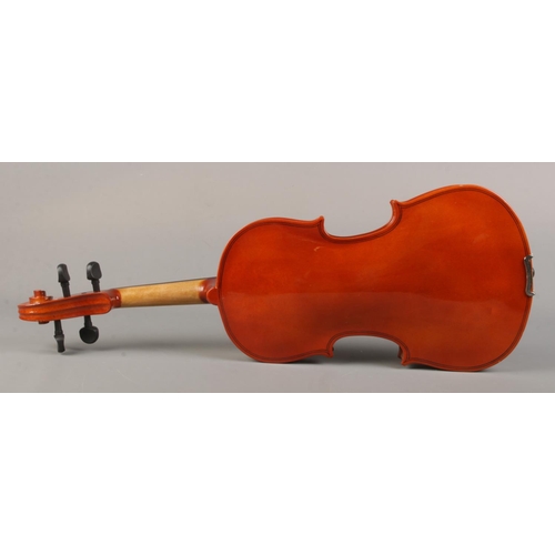 61 - A cased violin with bow. The violin having a one piece 14 inch back.