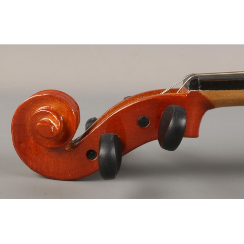 61 - A cased violin with bow. The violin having a one piece 14 inch back.