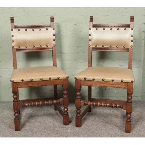 483 - A pair of Oak Old Charm dining chairs, model 2313. With spindle front stretcher and studded seat pad... 