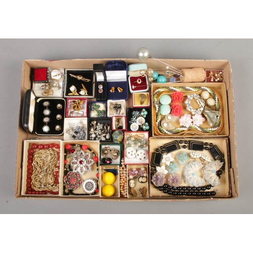 102 - A card tray containing a variety of vintage jewellery, including hat pins, clip on earrings, brooche... 