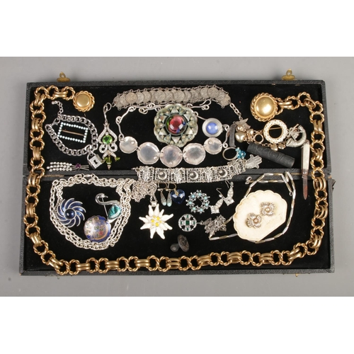 107 - A black box containing vintage costume jewellery, including Butler and Wilson belt, large brooches, ... 