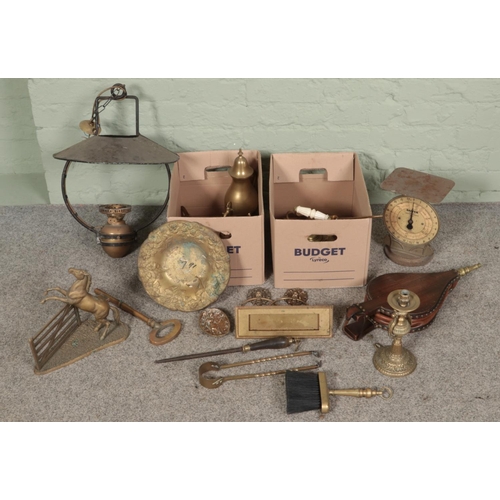 174 - Two boxes of mostly brassware. Includes rearing horse figure, large key, hanging oil lamp, erotic pl... 