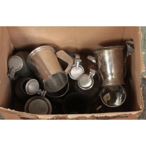 187 - A box of metalwares. Includes teapot, ewers, tankards, twin handle bowls, etc.