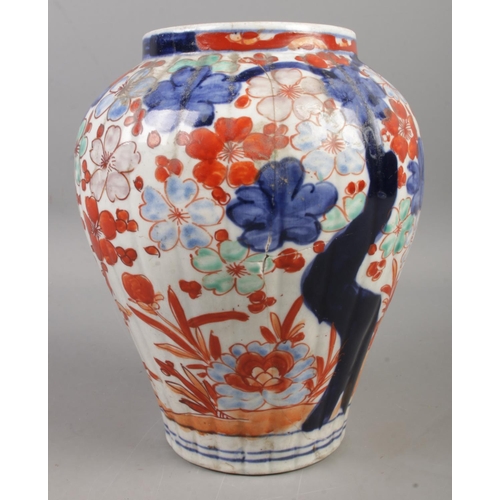 50 - A pair of Chinese lidded vases, decorated with Prunus blossom in blues and oranges, with pointed fin... 