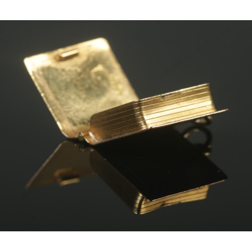 372 - A 9ct Gold charm, modelled as a 'Holy Bible', with hinged front cover. Stamped 375 to reverse. Total... 