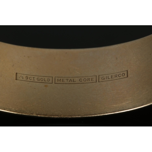 378 - A 9ct Gold and metal core hinged bangle, 1/5 9ct Gold. With half scrolled engraving, stamped for Gil... 