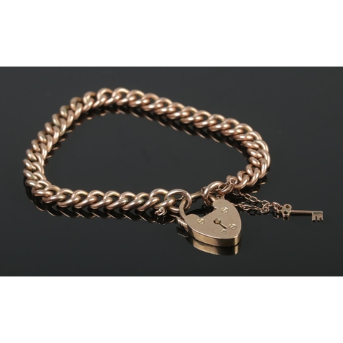 380 - A 9ct Rose Gold curb bracelet, featuring padlock and key charms. Total weight: 12.9g.