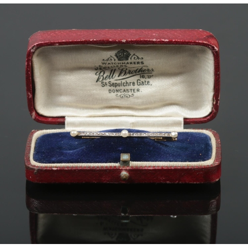 383 - A Gold and Platinum, Diamond and Pearl bar brooch in box. Length of brooch: 4cm. Total weight: 1.7g.