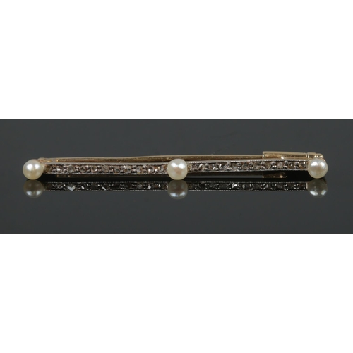 383 - A Gold and Platinum, Diamond and Pearl bar brooch in box. Length of brooch: 4cm. Total weight: 1.7g.