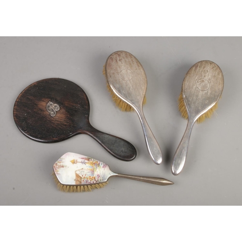 438 - Four dressing table items. Includes two early 20th century silver backed brushes, one brush with ena... 