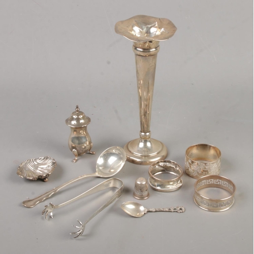 442 - A quantity of silver items. Includes trumpet vase, pepperette, napkin rings, thimble, spoons, salt c... 